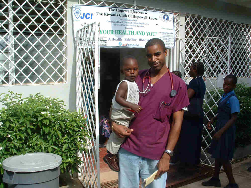 CHO volunteer with child at Jamaica health fair